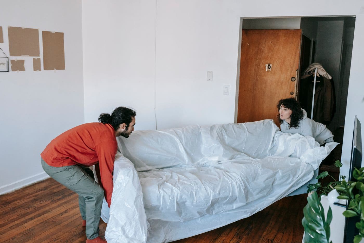 Zwei Mitarbeiter tragen ein Sofa aus einer Wohnung