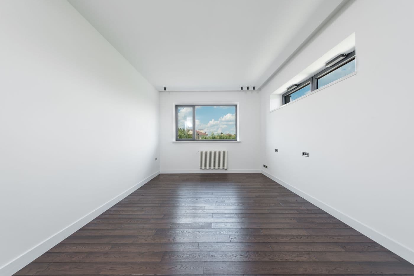 Besenrein geräumtes, helles Zimmer mit Holzboden nach einer Wohnungsauflösung